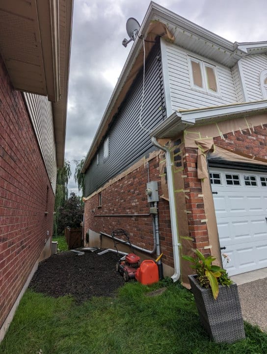 extensive masking and taping on a house exterior in preparation for spray painting in Welland