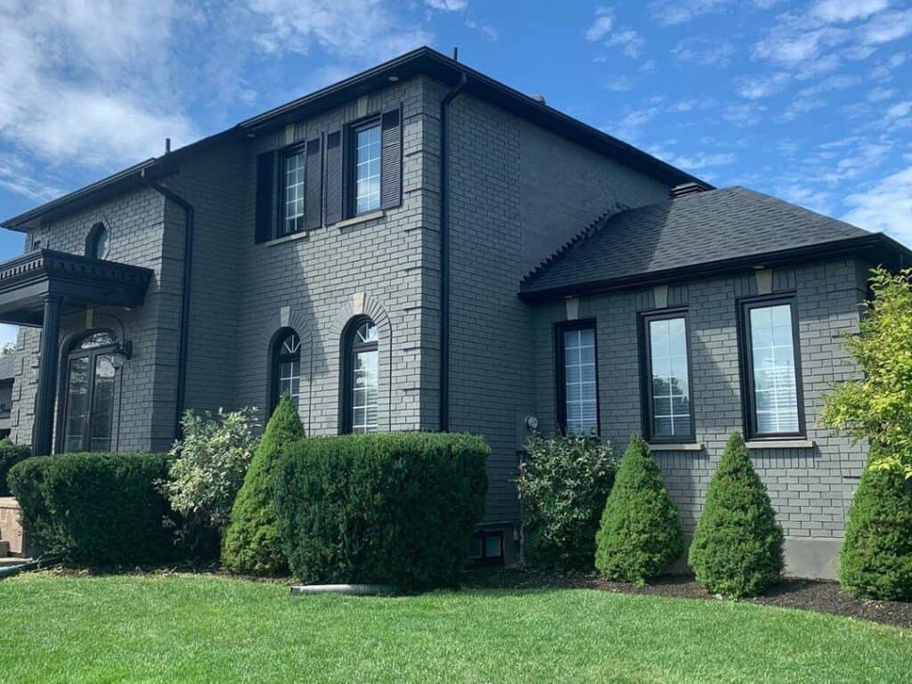 large brick house with brick painted grey and trim painted black.
