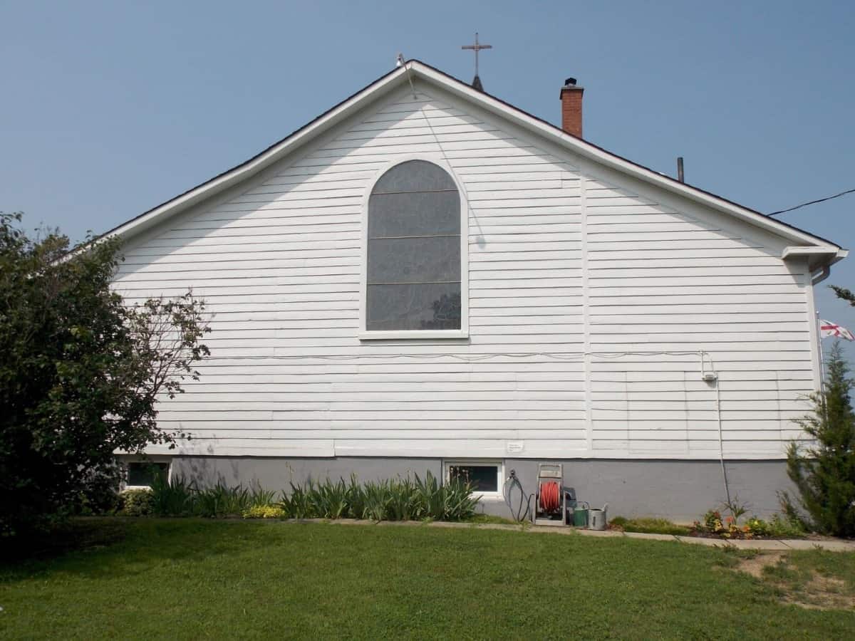Finished painted white wood siding on a church.