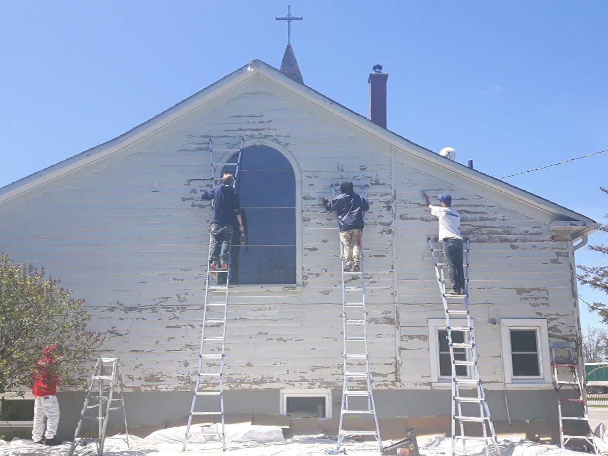 We Paint Siding crew refinishing wood siding on a church in Mississauga.