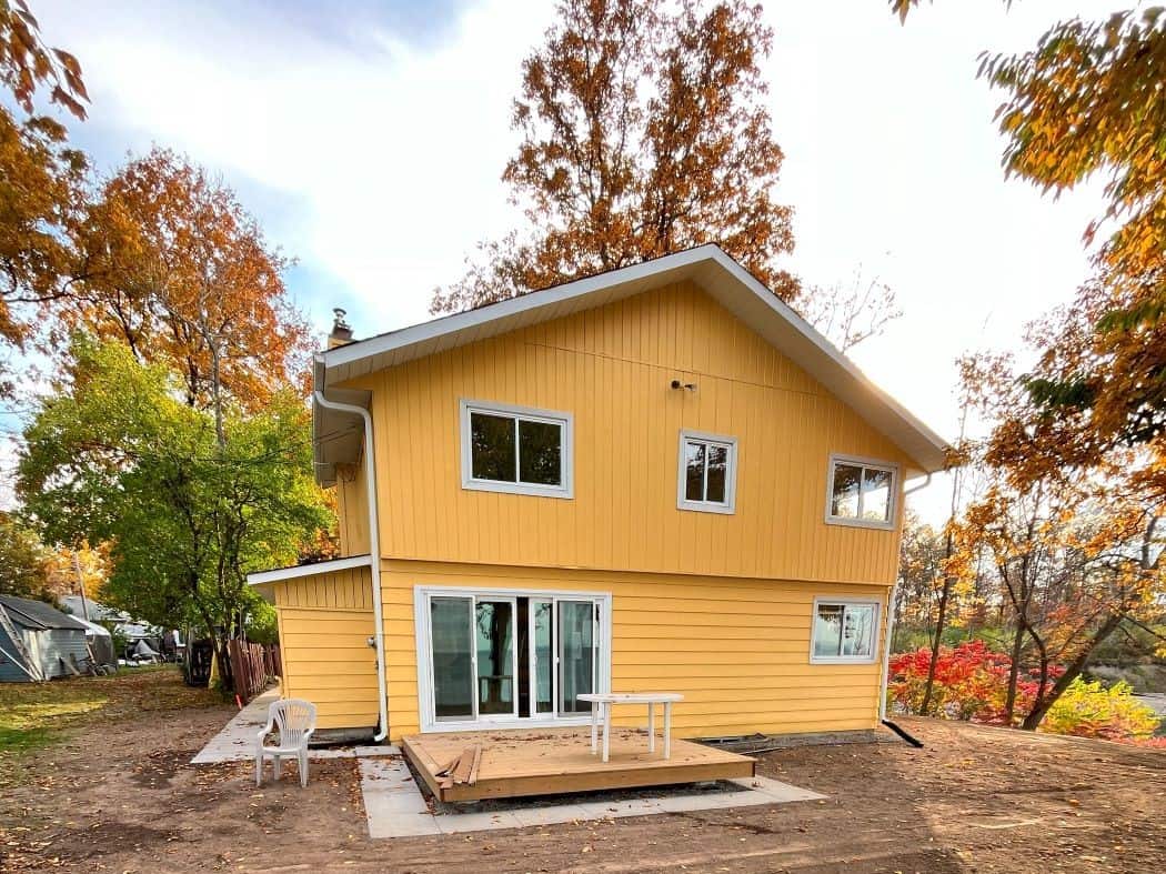 bright yellow wood and aluminum siding that was spray painted on a Fall day.